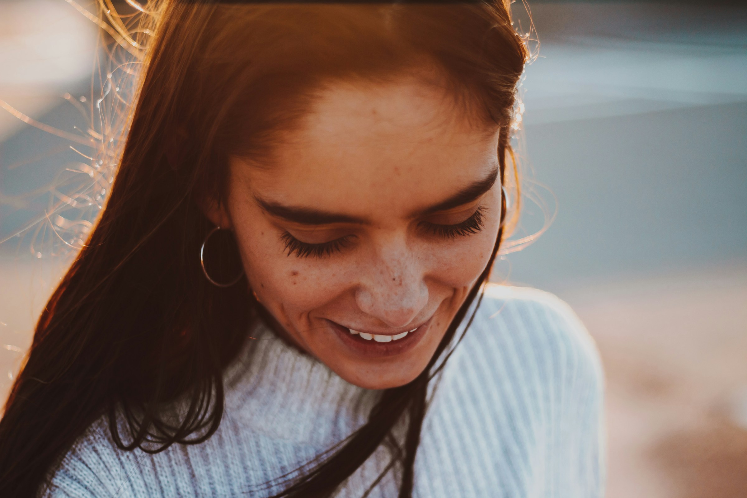 Woman with a gentle, contented smile in soft warm light